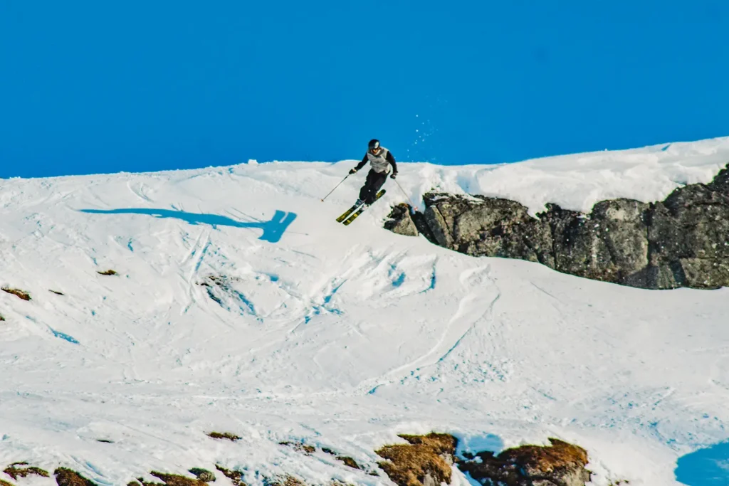 Skidåkare hoppar ut från en klippa i en freeridetävling.