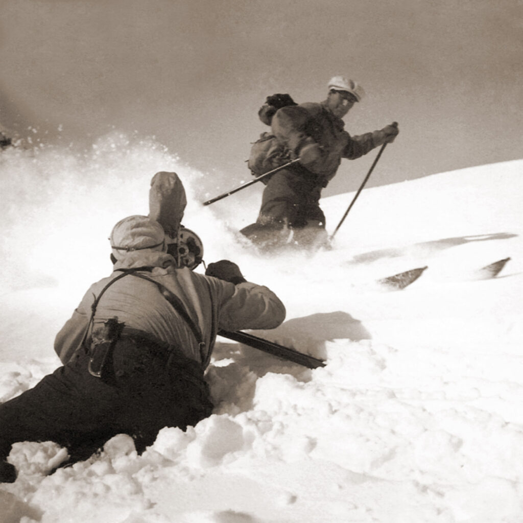 Recording of the film Igloo, Riksgränsen in April 1935. Olle Rimfors finishes a shot with a “hockey stop” right in front of photographer Åke Dahlqvist.