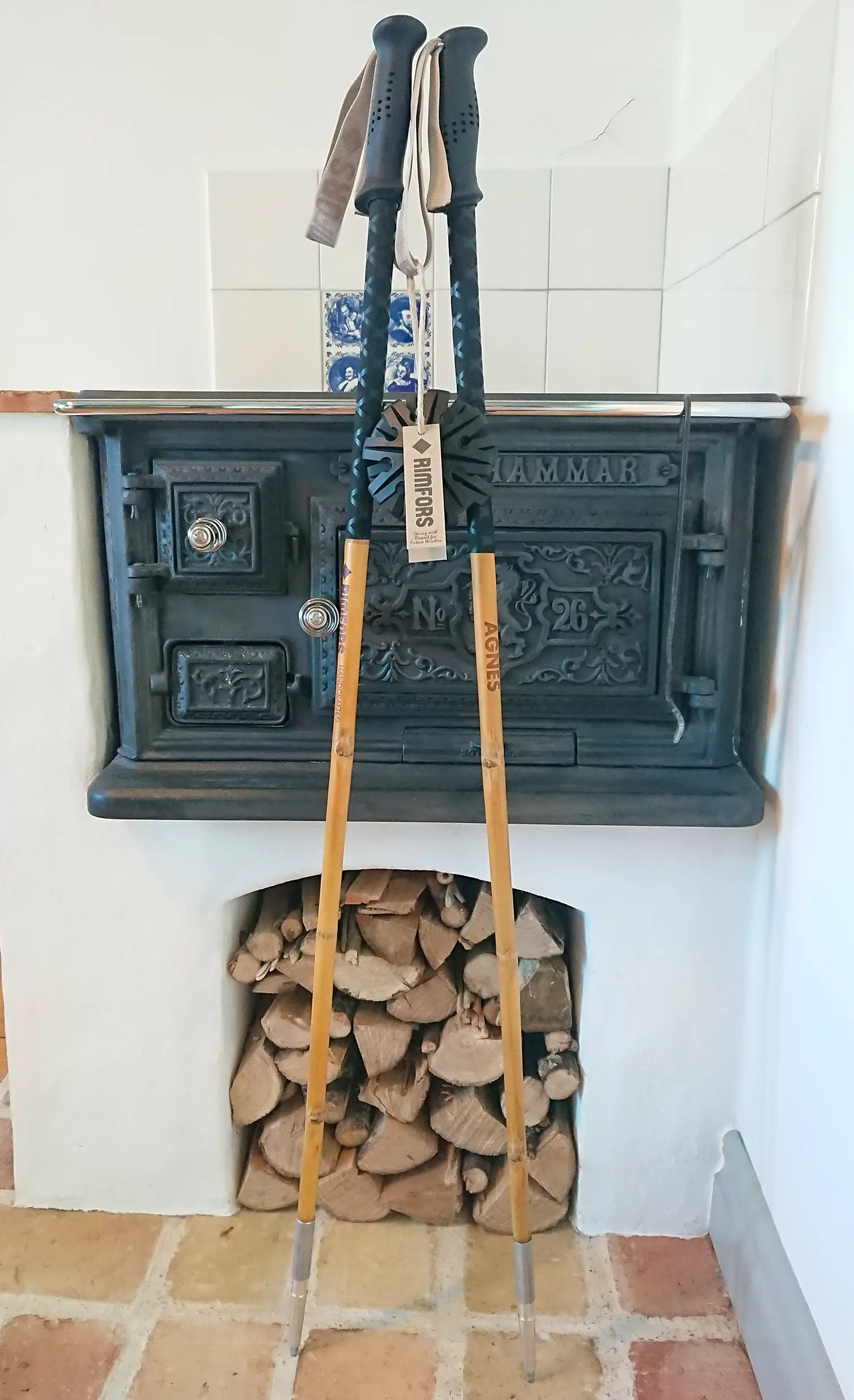 Skidstavar av bambu med svarta handtag och trugor, och förlängt grepp av krympslang, står framför en gjutjärnsspis.