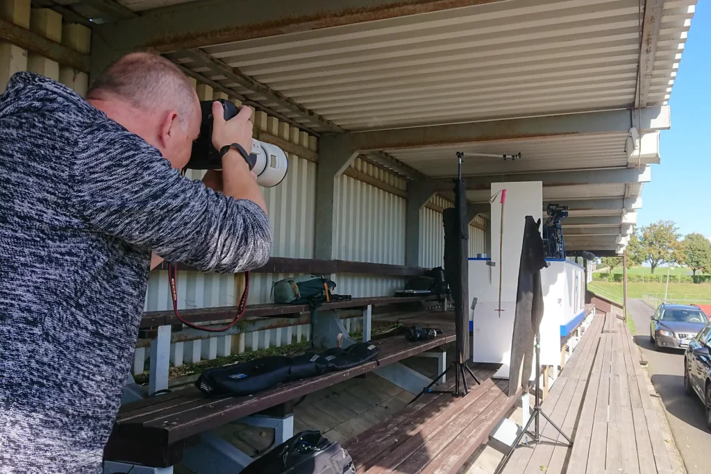 Andreas Hillergren photographs a ski pole in a makeshift photo studio set up in the grandstand at Simrishamn sports ground.