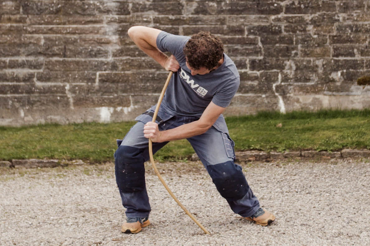 Bamboo cane being bent to demonstrate it's flexibility and strength as a ski pole.