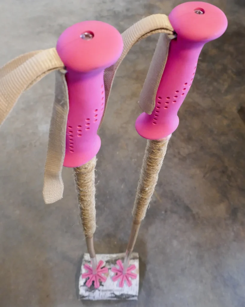 Ski poles of bamboo with pink grips and baskets, and grip extensions of wrapped hemp cord.