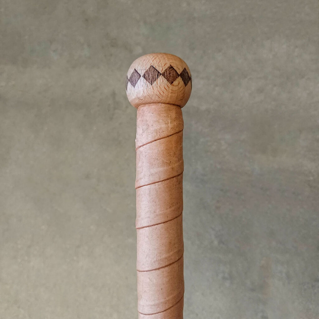 The reindeer leather grip is sealed with a birch knob at the top of the ski pole.