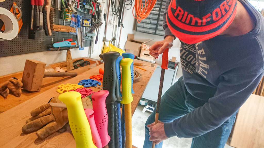 Fabian Rimfors is pressing on grips onto the bamboo ski poles with grip extensions.