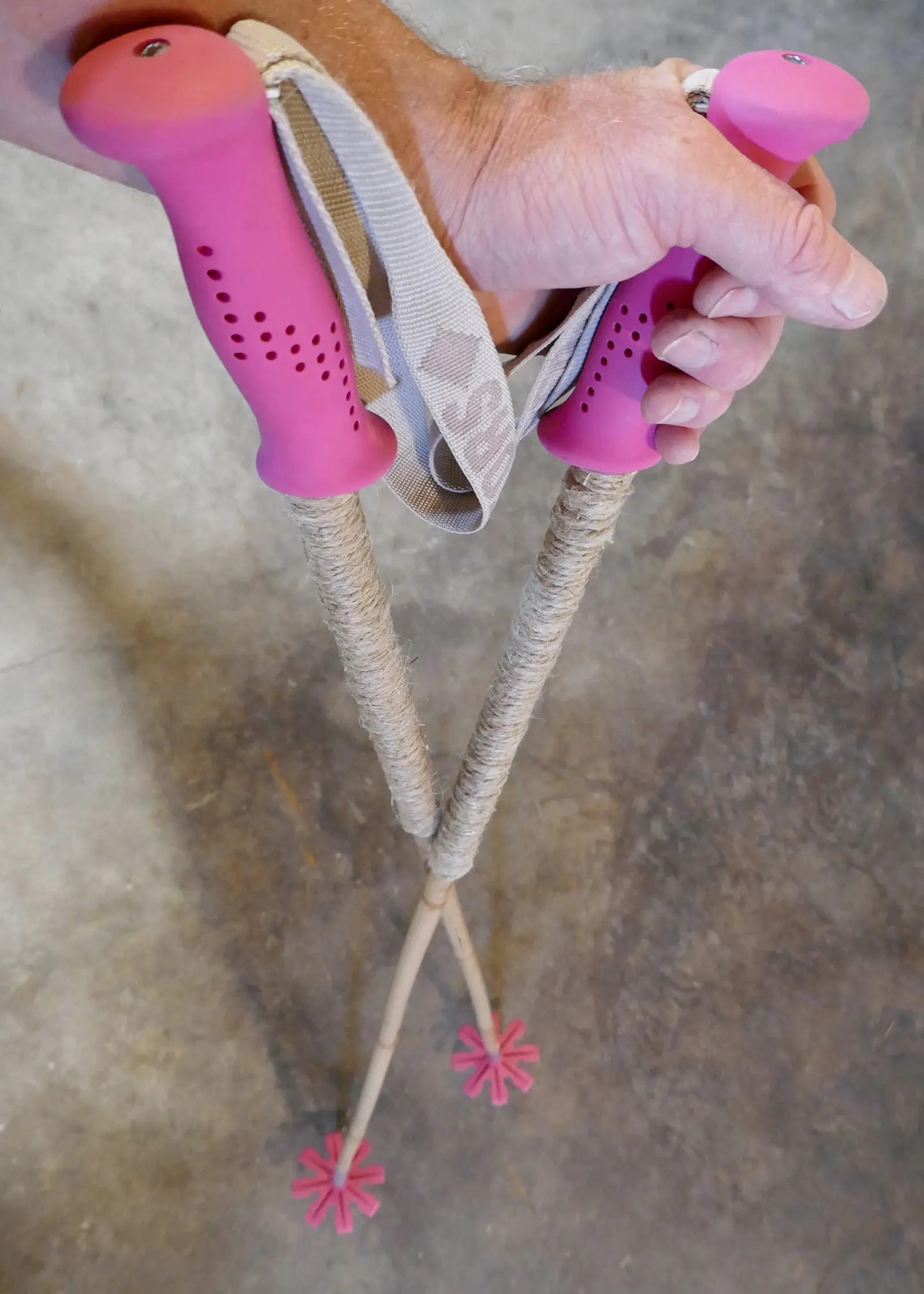 Bamboo ski poles with pink grips and baskets, and grip extensions of wrapped hemp twine.