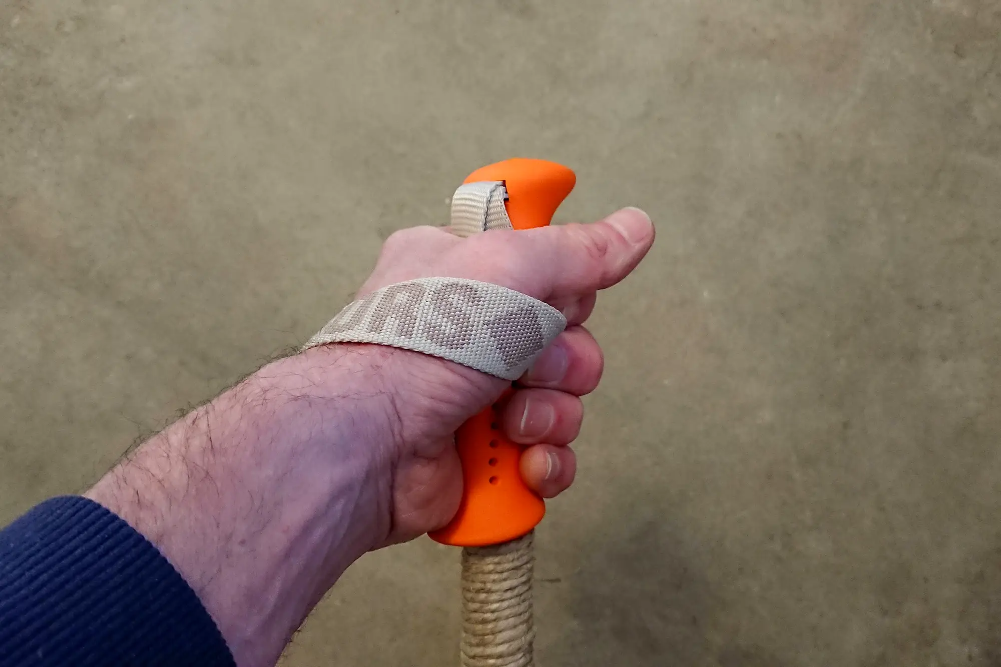 Hand som håller i en skidstav med orange handtag.
