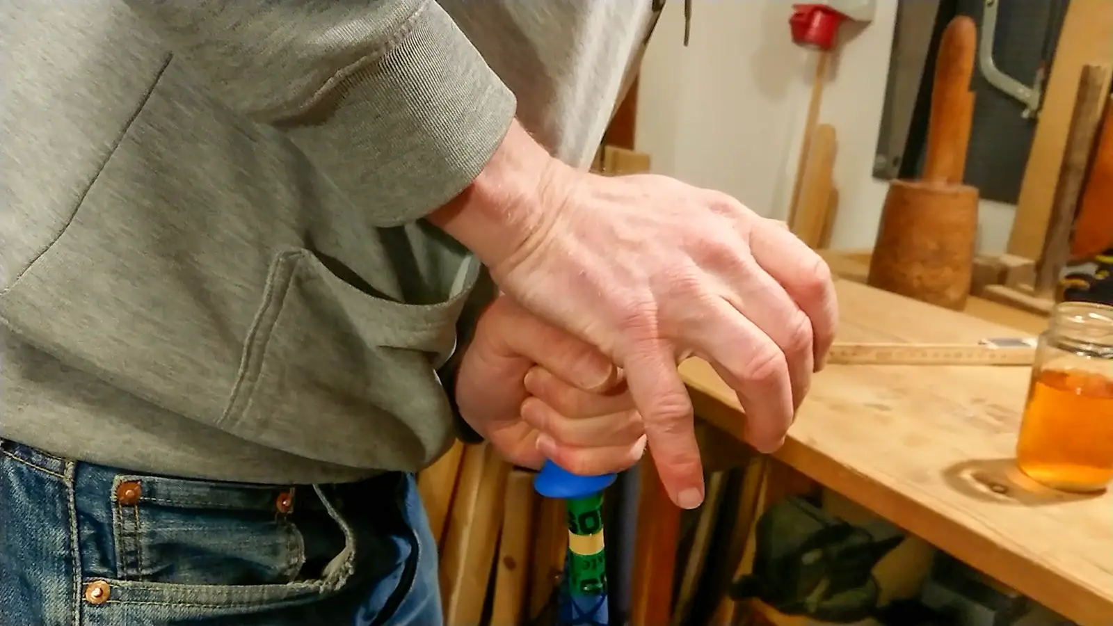 Pressar på ett blått handtag på en skidstav.