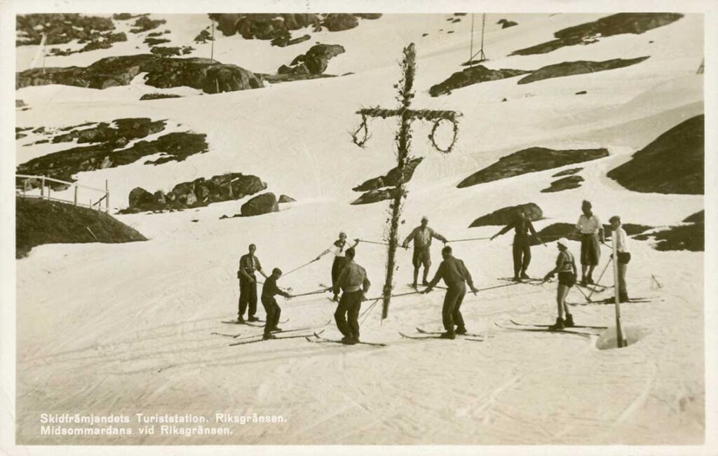 Skiers “dancing” around the midsummer pole in Riksgränsen in 1938. One lady wears a bikini.