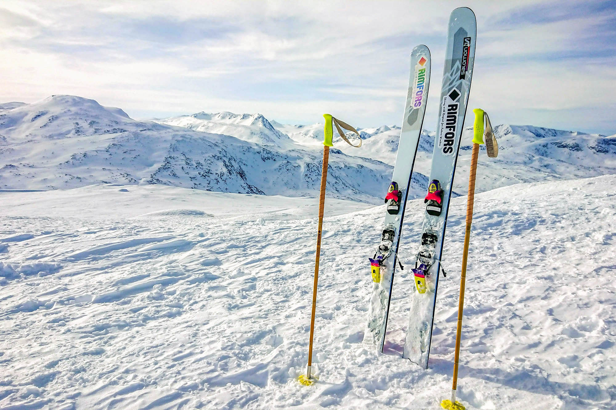 Fabian Rimfors' fluorescent yellow bamboo ski poles and Salomon QST Blank at the peak of Nordalsfjället in Riksgränsen, Sweden.