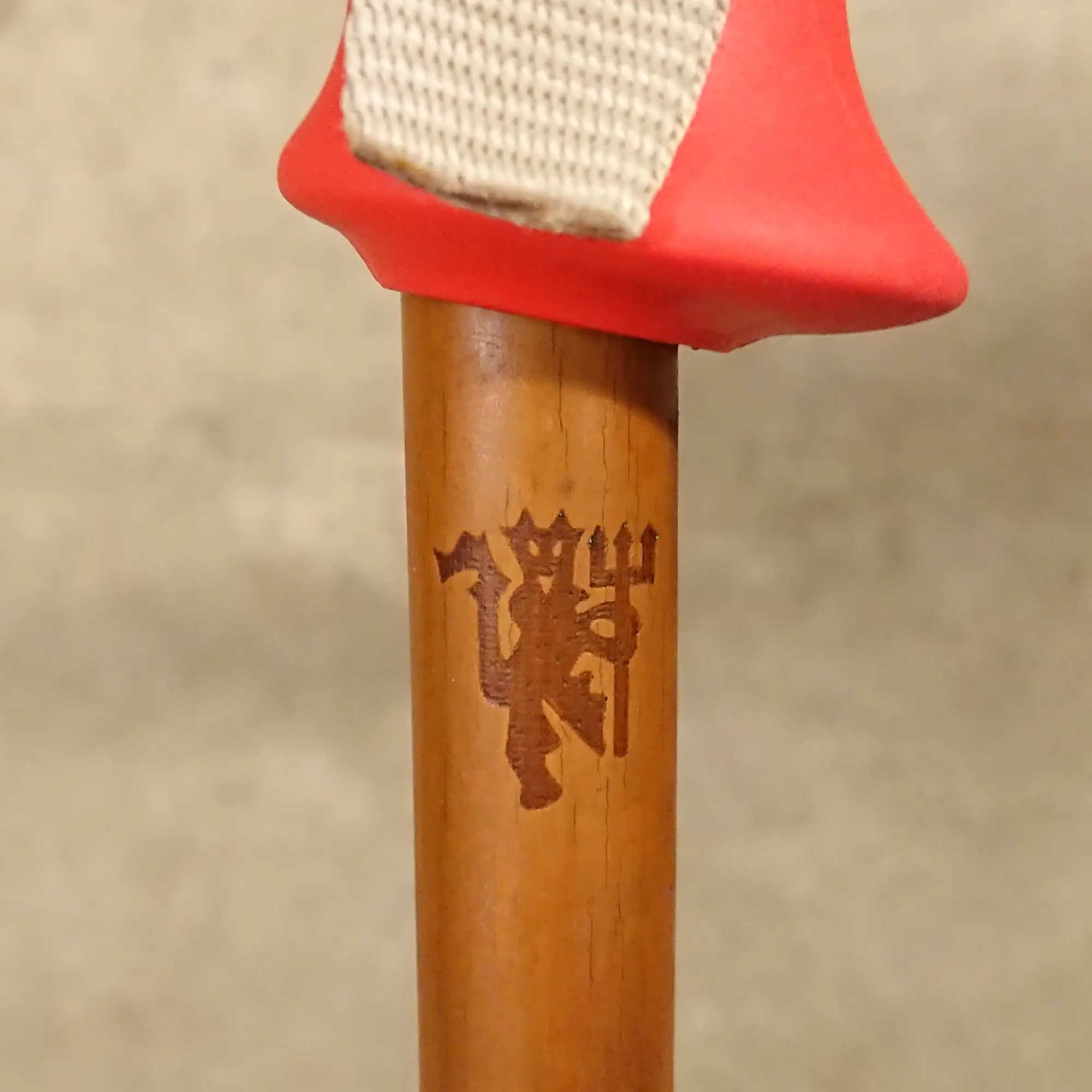 Dark bamboo ski pole with Manchester United red devil engraving.