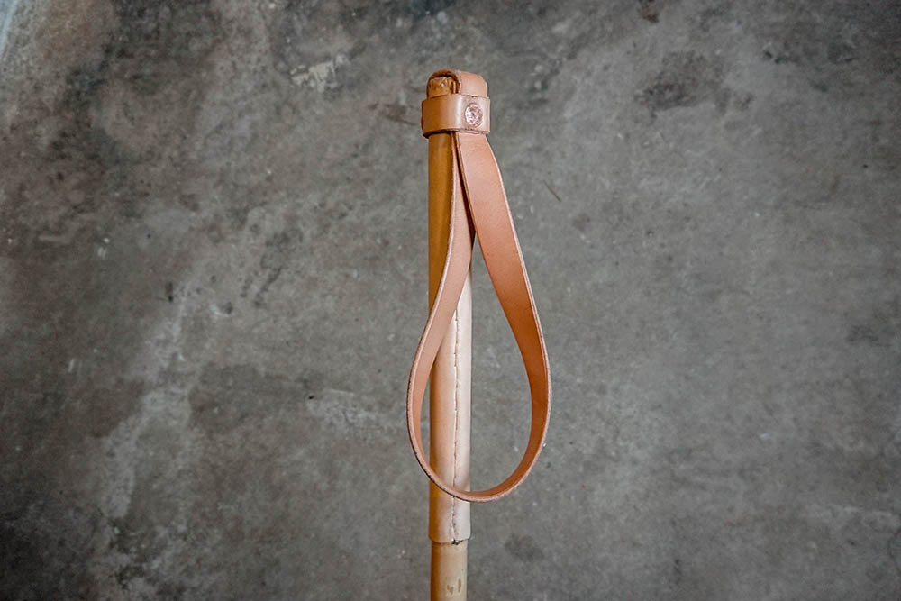 Traditional leather grip and strap on a classic bamboo ski pole.