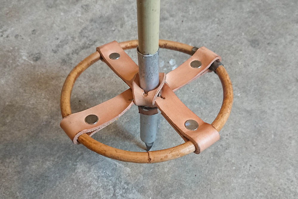 Crossed leather straps were a common way of making ski pole baskets. Here, the leather is attached to the rattan ring with rivets.