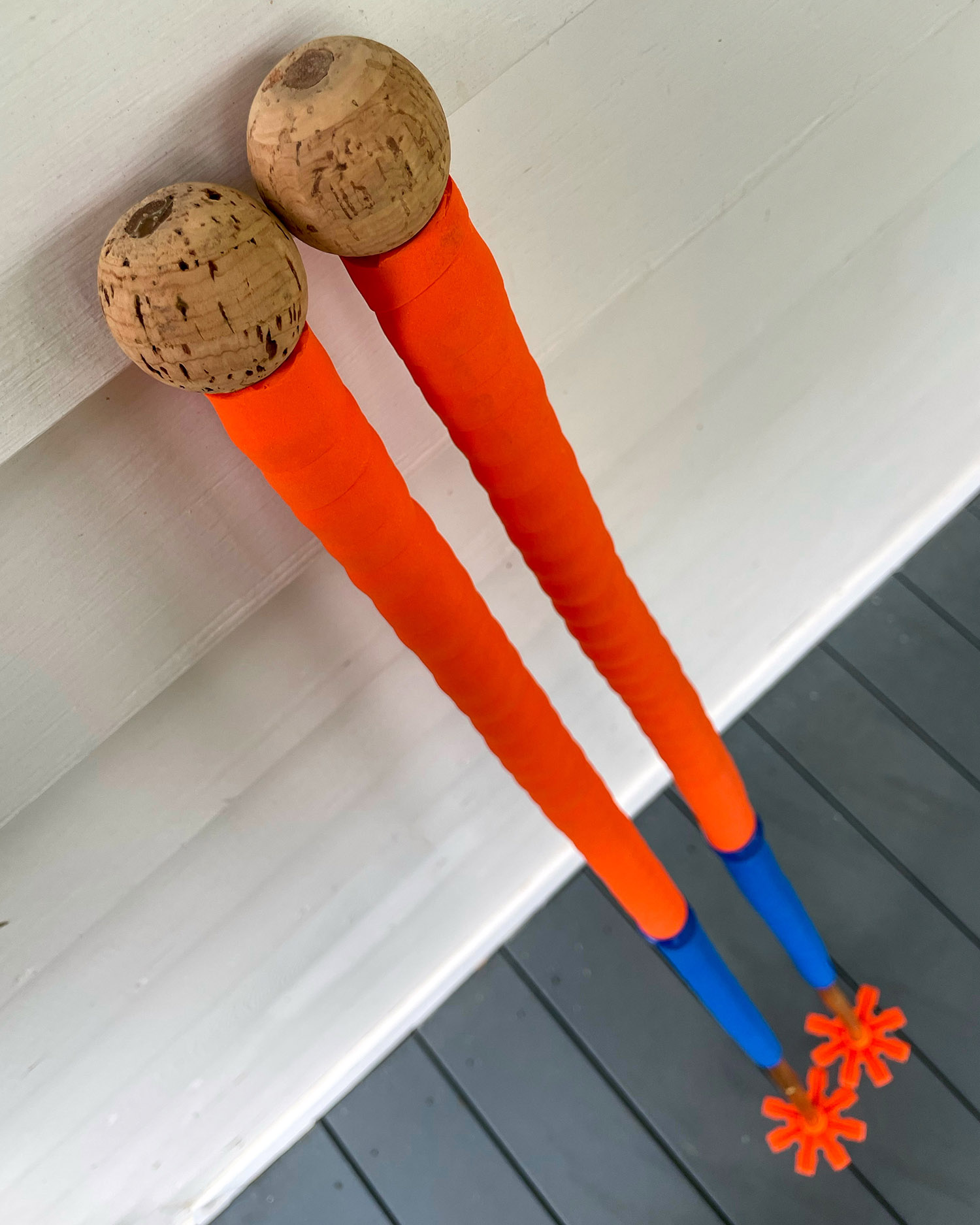 Bamboo ski touring poles with orange and blue handlebar tape for grip extension.